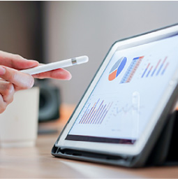 Person pointing at graphs on a tablet screen